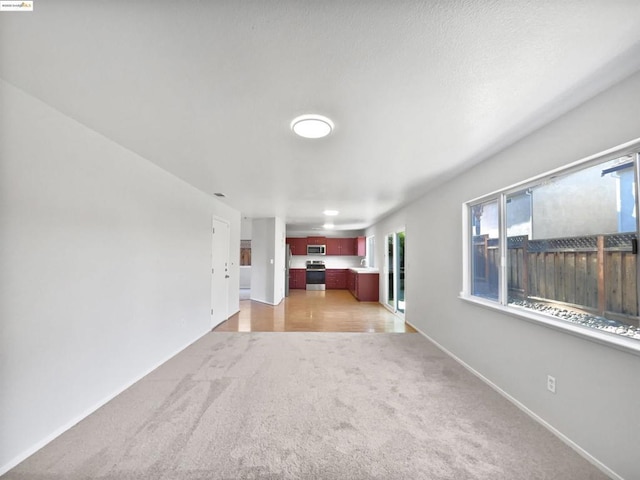 unfurnished living room with light colored carpet