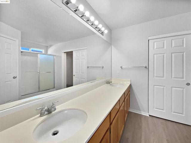 bathroom with wood-type flooring, vanity, and an enclosed shower