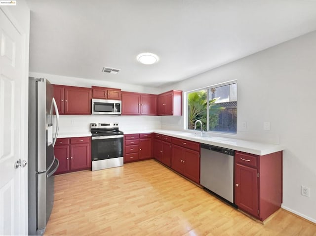 kitchen featuring light wood-type flooring, appliances with stainless steel finishes, and sink