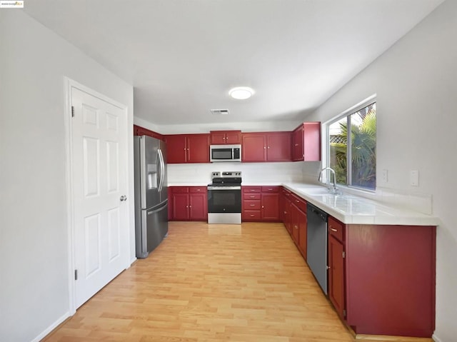 kitchen featuring light wood-type flooring, appliances with stainless steel finishes, and sink