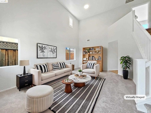 living room featuring light carpet and a towering ceiling