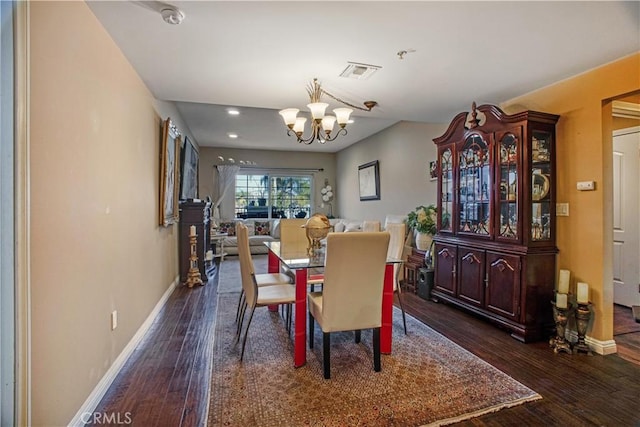 dining area featuring an inviting chandelier and dark hardwood / wood-style flooring