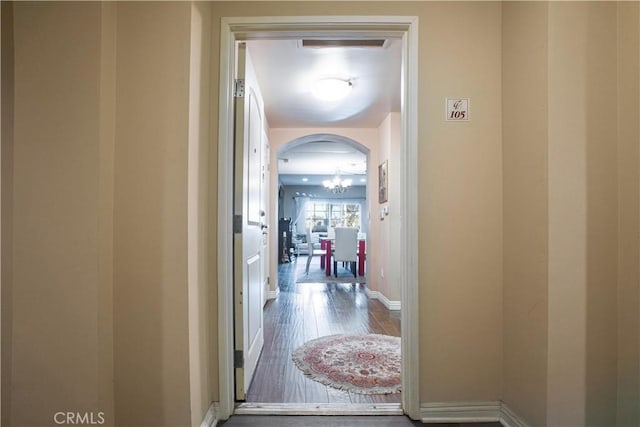 hall featuring an inviting chandelier and hardwood / wood-style flooring