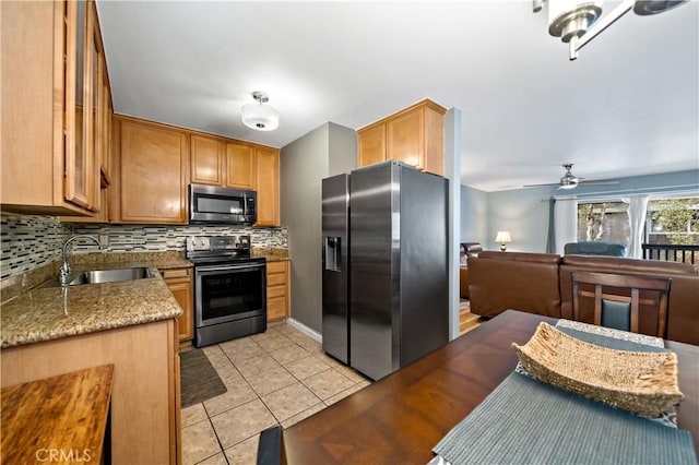 kitchen with light tile patterned flooring, appliances with stainless steel finishes, decorative backsplash, and sink