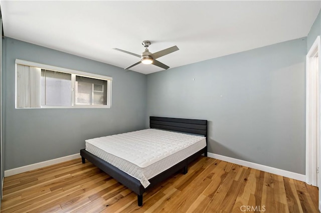 bedroom with ceiling fan and light hardwood / wood-style flooring