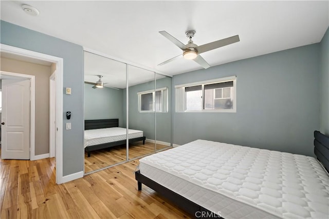 bedroom featuring ceiling fan, a closet, and hardwood / wood-style floors