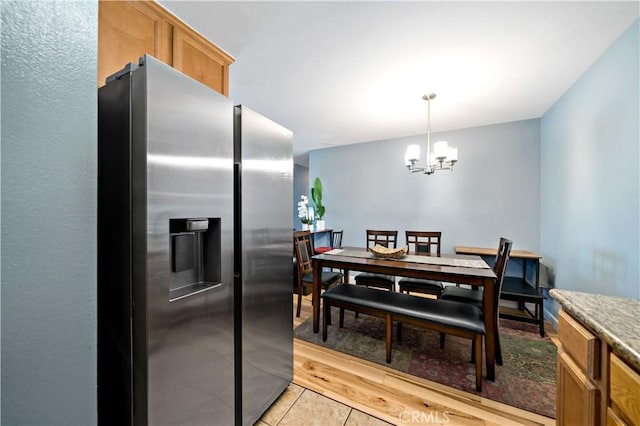 dining space with an inviting chandelier and light tile patterned flooring