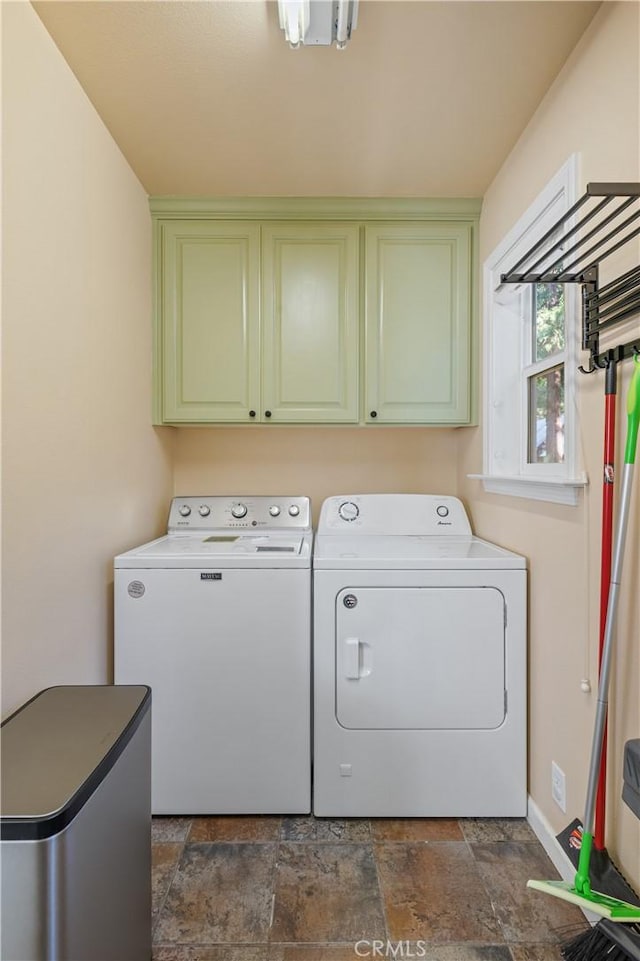 laundry room with washing machine and dryer and cabinets