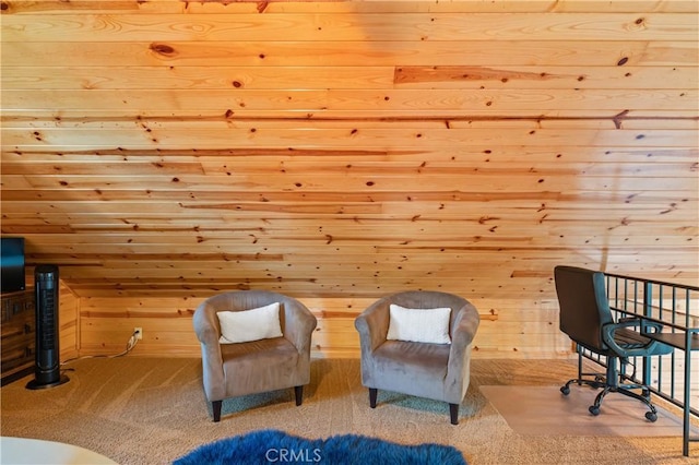 living area with light carpet and wooden walls