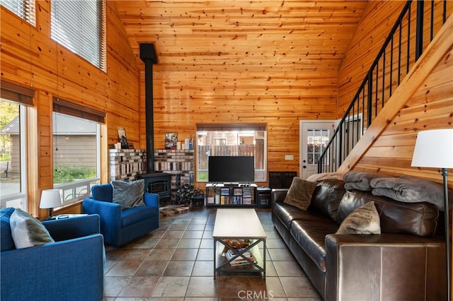 tiled living room with wood ceiling, a wood stove, wooden walls, and high vaulted ceiling