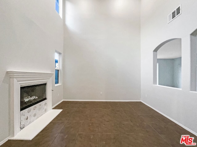 unfurnished living room with a towering ceiling