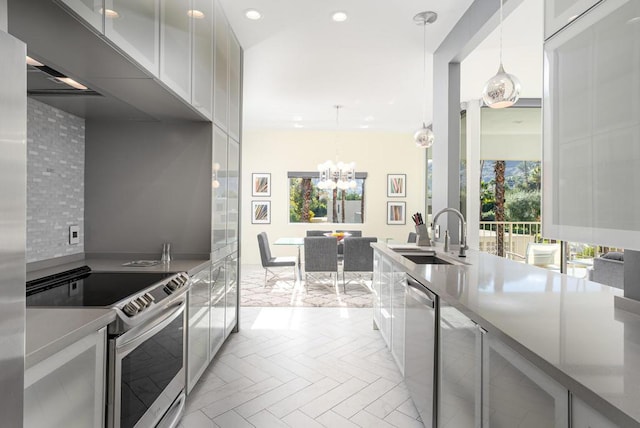 kitchen with light parquet flooring, backsplash, sink, stainless steel appliances, and white cabinets