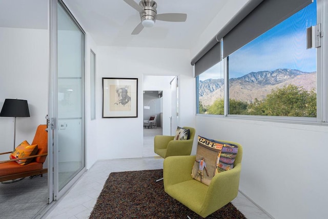 sitting room featuring a mountain view and ceiling fan