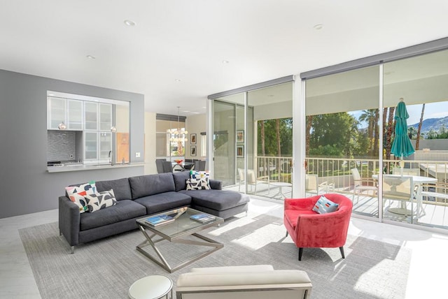 living room featuring a wealth of natural light, a wall of windows, and an inviting chandelier