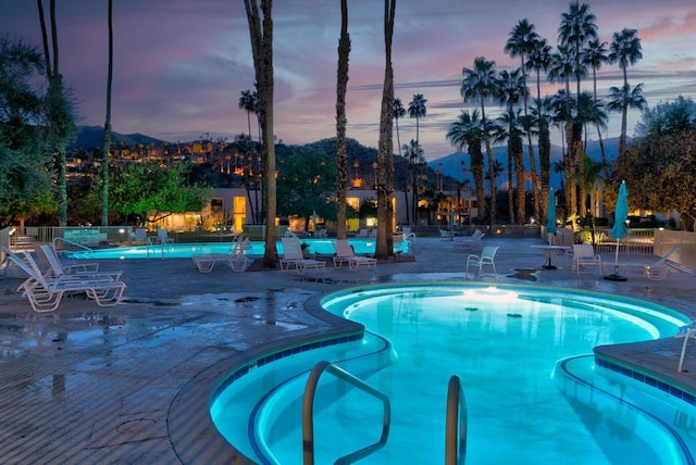 pool at dusk with a patio