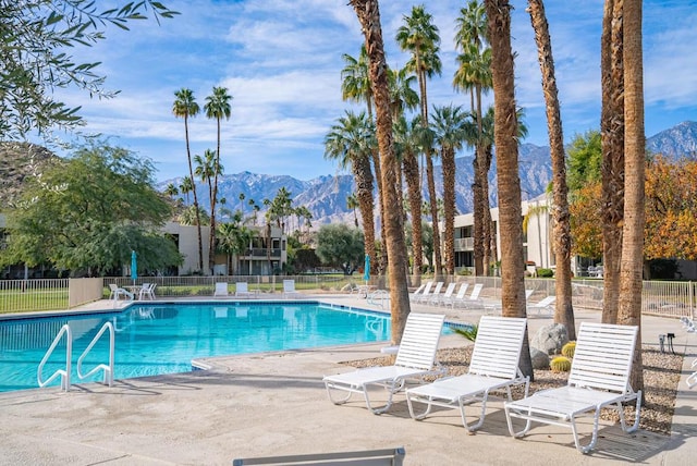 view of swimming pool featuring a mountain view and a patio