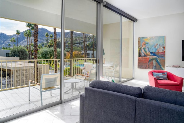 doorway to outside with expansive windows, plenty of natural light, and a mountain view