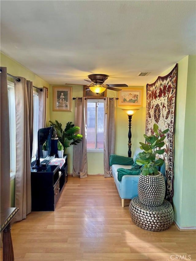 living area featuring ceiling fan and light wood-type flooring