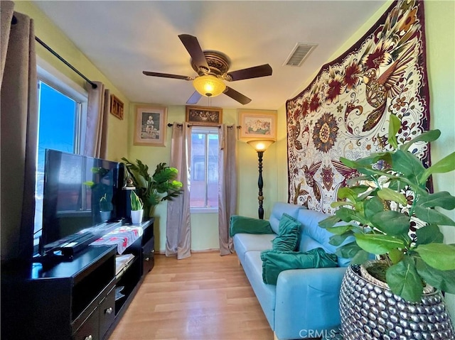 living room with ceiling fan and light hardwood / wood-style floors