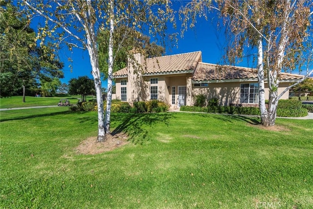 mediterranean / spanish home with a front lawn