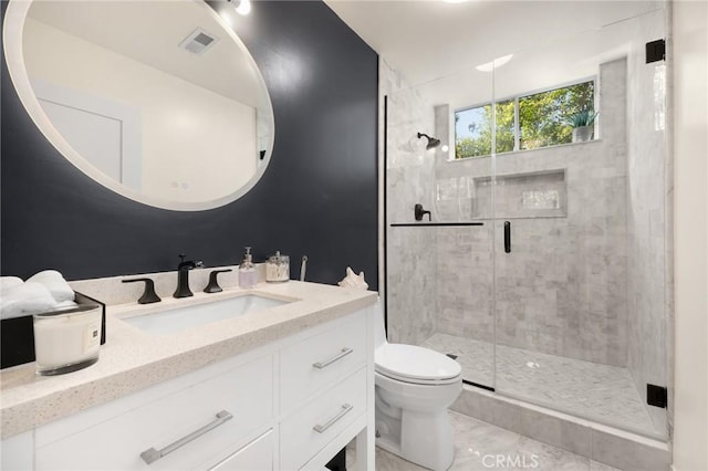 bathroom featuring toilet, tile patterned flooring, a shower with shower door, and vanity