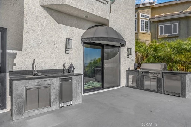 view of patio featuring an outdoor kitchen, sink, and a grill