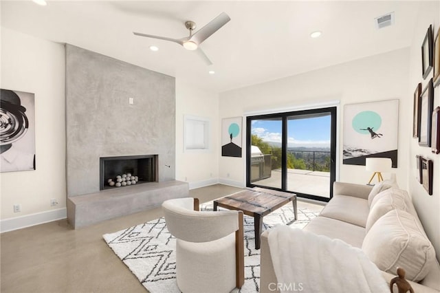 living room with ceiling fan and a fireplace