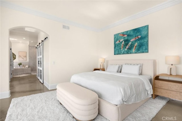 bedroom featuring crown molding and a barn door