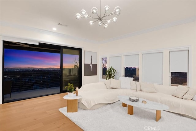 living room featuring crown molding, an inviting chandelier, and hardwood / wood-style flooring