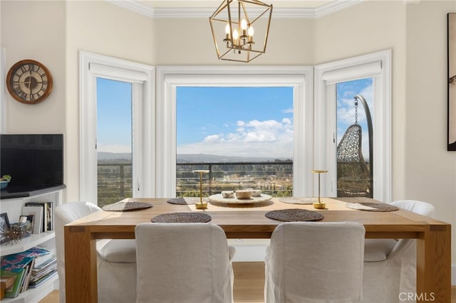 dining room with a wealth of natural light, crown molding, and a notable chandelier