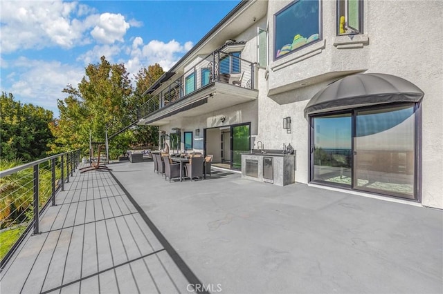 wooden deck with a patio area and exterior kitchen