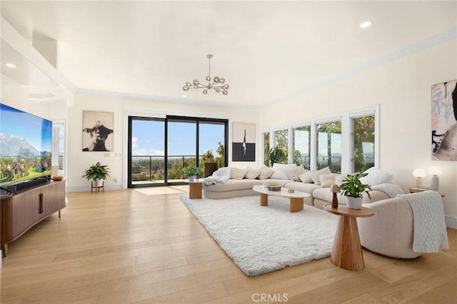 living room with crown molding, light wood-type flooring, and an inviting chandelier