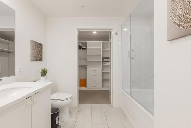 full bathroom featuring vanity, tile patterned floors, shower / bath combination with glass door, and toilet