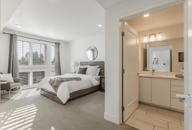 bedroom featuring sink and light colored carpet