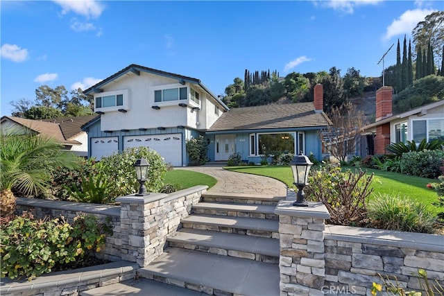 view of front of house featuring a garage and a front lawn