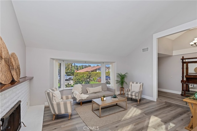 living room featuring a fireplace, hardwood / wood-style floors, and high vaulted ceiling