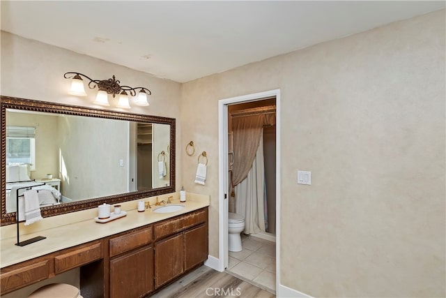 bathroom featuring toilet, hardwood / wood-style flooring, and vanity