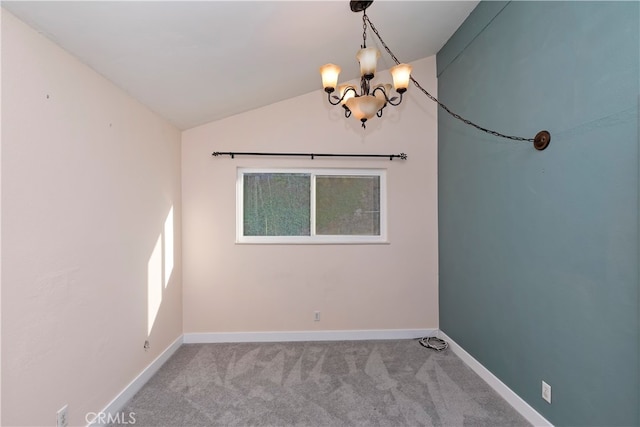 carpeted empty room featuring a chandelier and lofted ceiling