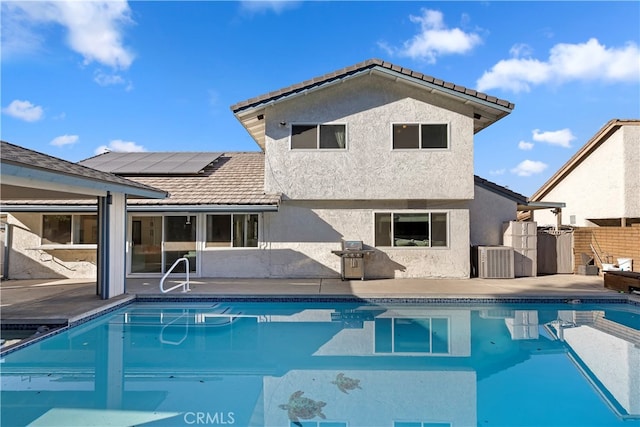 view of pool featuring a patio area, a grill, and central AC