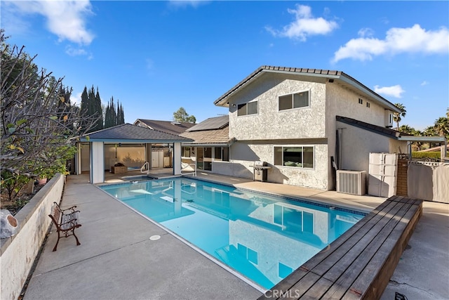 view of swimming pool featuring central AC, a gazebo, a patio area, and grilling area