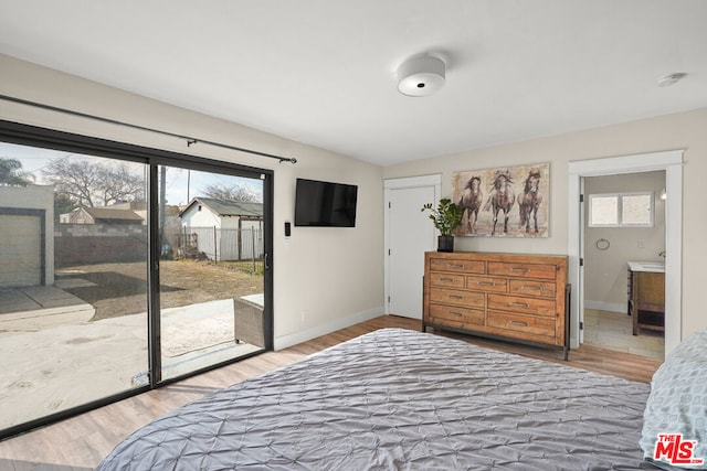 bedroom featuring ensuite bath, access to outside, and wood-type flooring