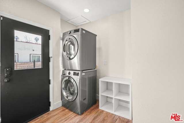 washroom with stacked washing maching and dryer and light hardwood / wood-style flooring