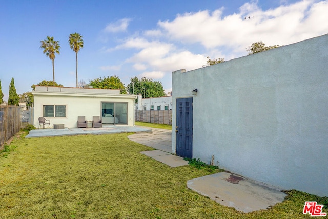 rear view of property with a yard and a patio area