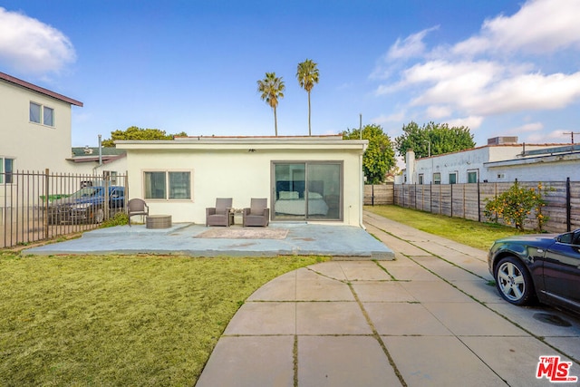 back of house featuring a patio and a lawn