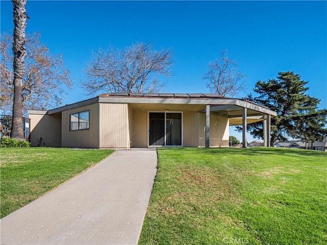 view of front of property with a front yard and a carport