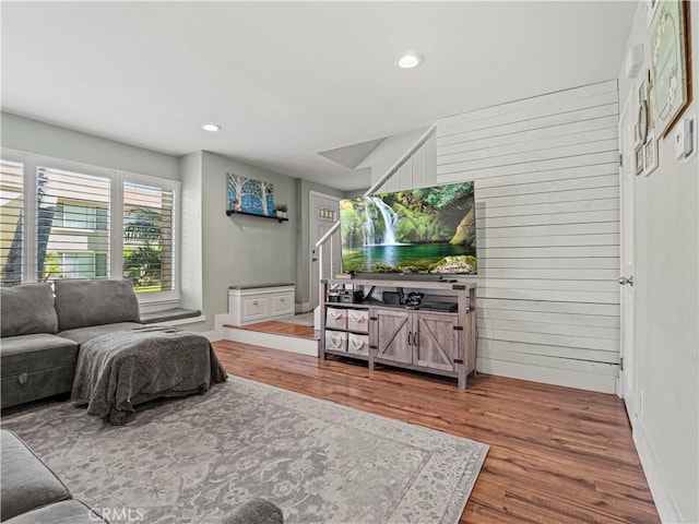 living room featuring hardwood / wood-style flooring and wood walls