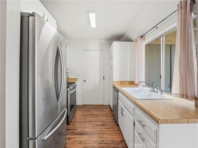 kitchen with sink, white cabinetry, appliances with stainless steel finishes, and dark hardwood / wood-style flooring