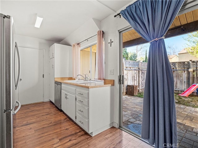 kitchen featuring sink, wood-type flooring, white cabinets, and stainless steel appliances