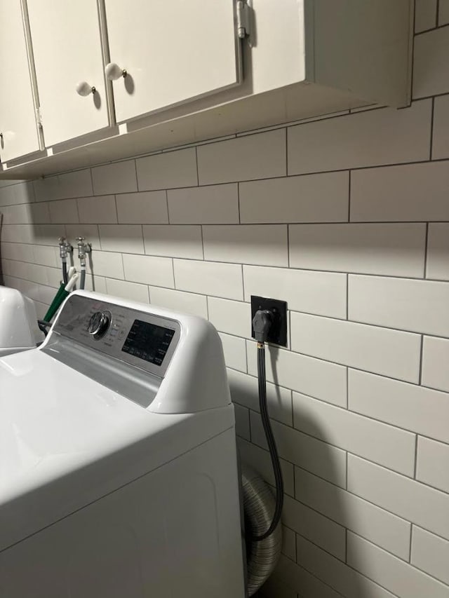 washroom with cabinets and washer / clothes dryer