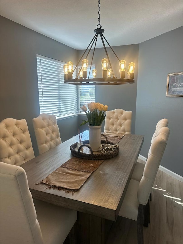 dining room with wood-type flooring and a notable chandelier